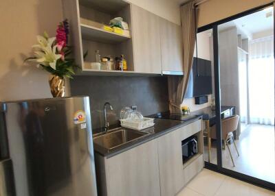 Modern compact kitchen with stainless steel appliances and a bright atmosphere
