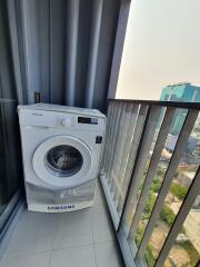 Compact balcony with a washing machine overlooking the city