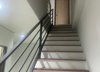 Modern staircase with wooden steps and metal railing in a residential property