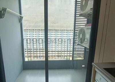 Compact balcony with a glass door and urban view