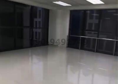 Spacious unfurnished commercial space with large windows and reflective flooring