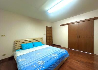 Spacious bedroom with hardwood flooring and built-in wardrobe