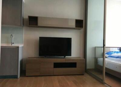 Modern bedroom with entertainment unit and sliding door to the adjacent room