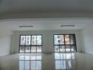 Spacious empty interior of a modern building with large windows and glossy tiled flooring