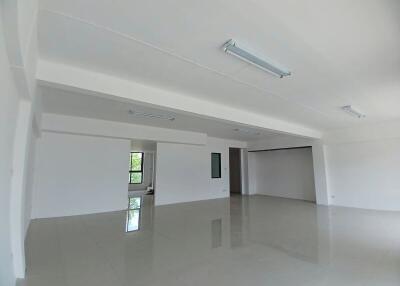 Spacious empty room with large windows and glossy floor