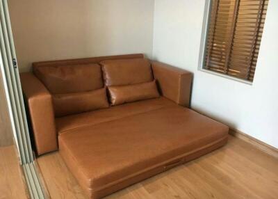 Brown leather sofa in a simple living room with wooden flooring