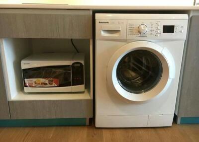 Modern laundry area with washer and microwave oven
