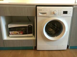 Modern laundry area with washer and microwave oven