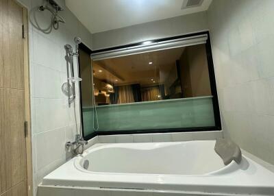 Spacious bathroom with large bathtub and frosted glass window