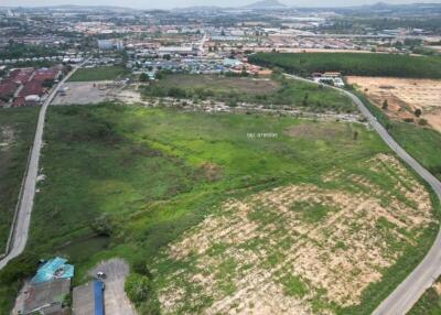 Aerial view of an empty land plot available for development near a residential area