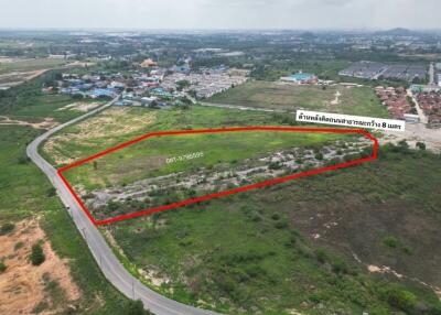 Aerial view of a vacant land plot outlined in red for potential real estate development