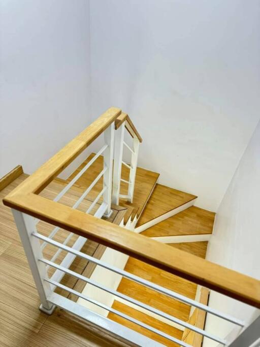 Modern wooden staircase with white balusters and handrails