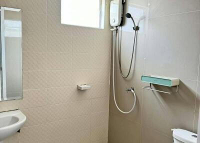 Modern bathroom with beige tiles, shower, and basic fixtures