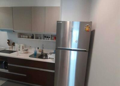 Modern kitchen with stainless steel refrigerator and ample cabinet space