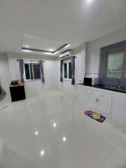 Spacious and modern kitchen with glossy tiled flooring and ample natural light