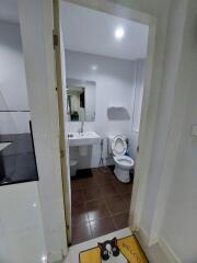 Compact bathroom with white fixtures and tiled floor