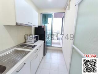 Compact modern kitchen with stainless steel appliances and a city view from the balcony access
