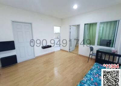 Spacious bedroom with a large bed, laminate flooring, and ample natural light