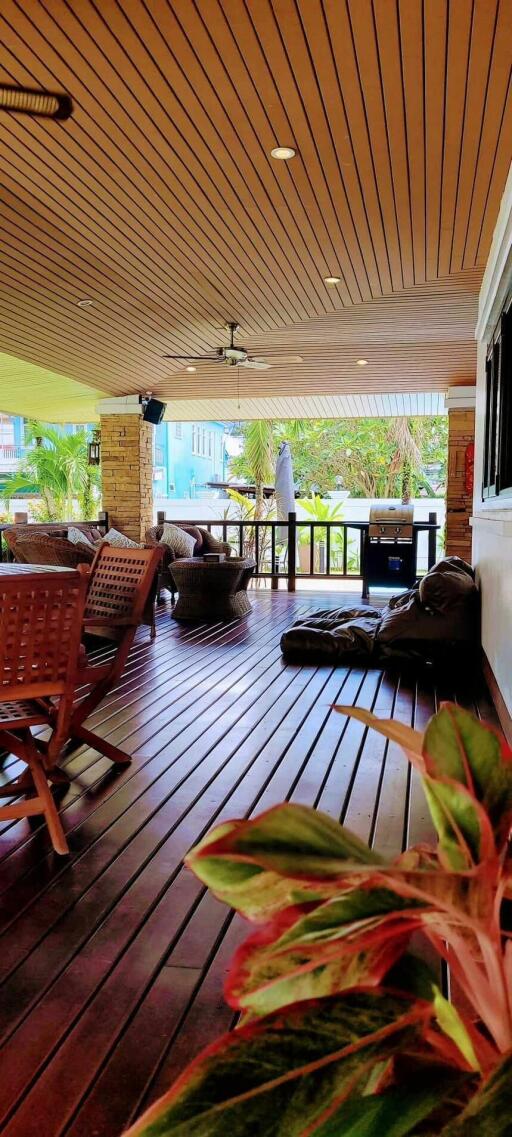 Spacious covered patio with comfortable seating and wooden decking