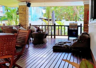 Spacious covered patio with comfortable seating and wooden decking