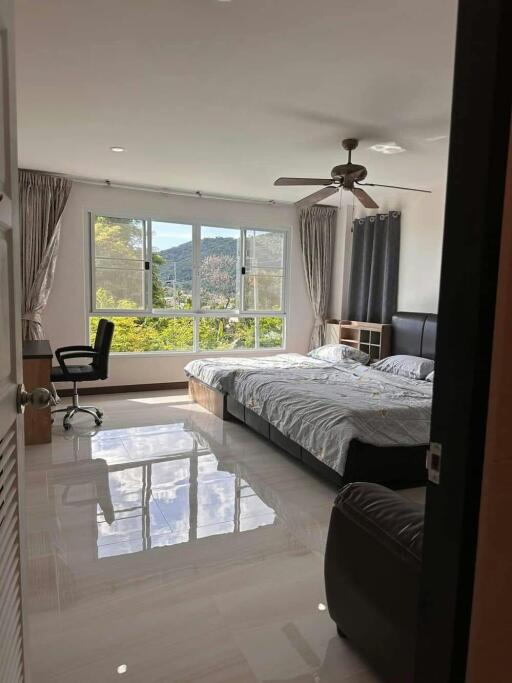 Spacious bedroom with natural lighting and scenic view