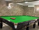 Spacious game room with a professional snooker table and stone accent walls