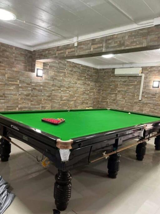 Spacious game room with a professional snooker table and stone accent walls