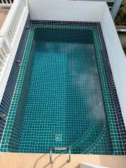 Private outdoor swimming pool with blue mosaic tiles