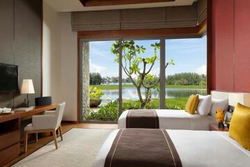 Spacious bedroom with a large bed, natural lighting, and a view of the lawn