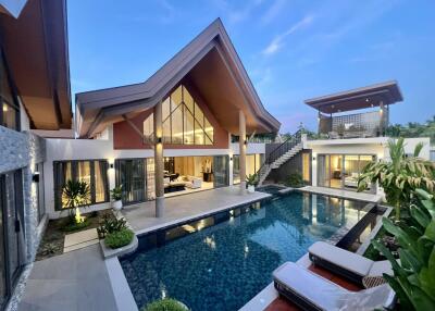 Luxurious modern villa with an illuminated swimming pool at dusk