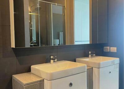 Modern bathroom with dual vanity sinks, large mirror, and elegant lighting