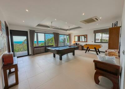 Spacious recreation room with pool table and ocean view