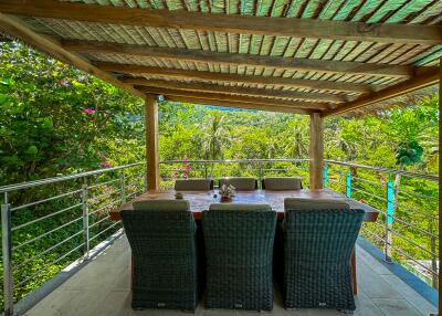 Spacious outdoor patio with lush greenery view and dining set