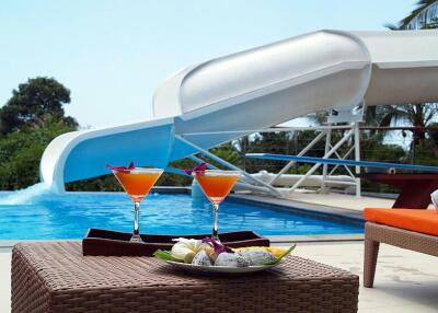 Luxurious poolside area with slide and refreshments