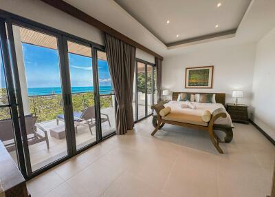 Bright bedroom with ocean view and balcony access through large sliding glass doors
