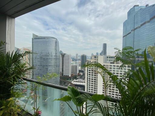 Spacious balcony with a breathtaking city skyline view and green plants