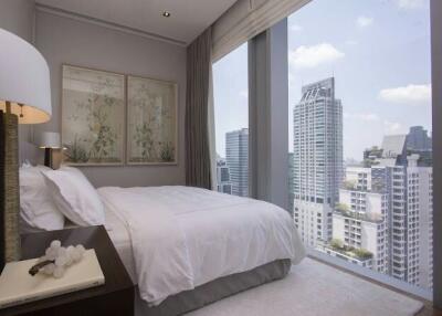 Modern bedroom with a large bed and floor-to-ceiling windows overlooking the city