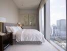 Cozy modern bedroom with a city view through large windows