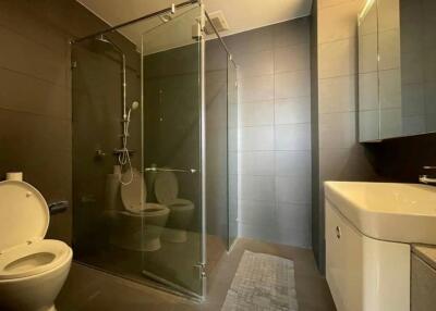Modern bathroom with glass shower enclosure and tiled walls