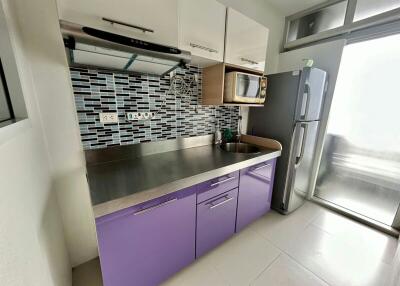 Modern kitchen with stainless steel appliances and purple cabinetry