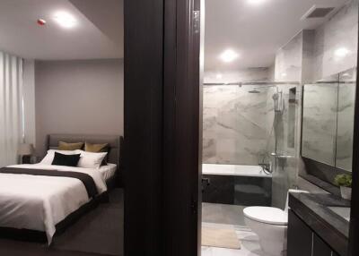 Modern bedroom with en-suite bathroom featuring glass walls