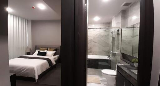 Modern bedroom with en-suite bathroom featuring glass walls