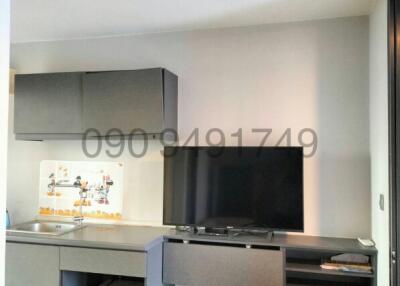 Modern living room interior with television and a compact kitchenette