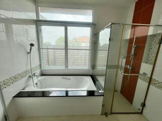 Spacious modern bathroom with large window and glass shower