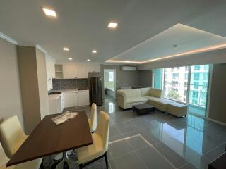 Spacious and well-lit apartment main living area with an open kitchen layout, modern furniture, and balcony access