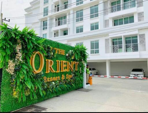 Exterior view of The Orient Resort and Spa with decorative green foliage wall
