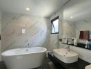 Modern bathroom with standalone tub and marble walls