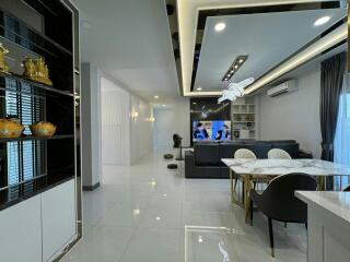 Modern and spacious living room with dining area and television