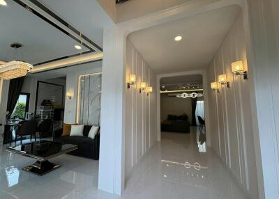 Elegant hallway leading to a sophisticated living area with modern lighting fixtures and marble floor