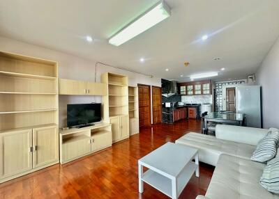 Spacious living room with modern furnishings and open plan kitchen